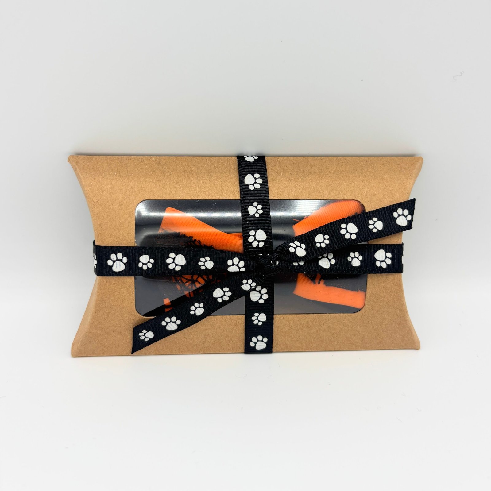 Halloween dog bow in a gift box tied with paw-print ribbon