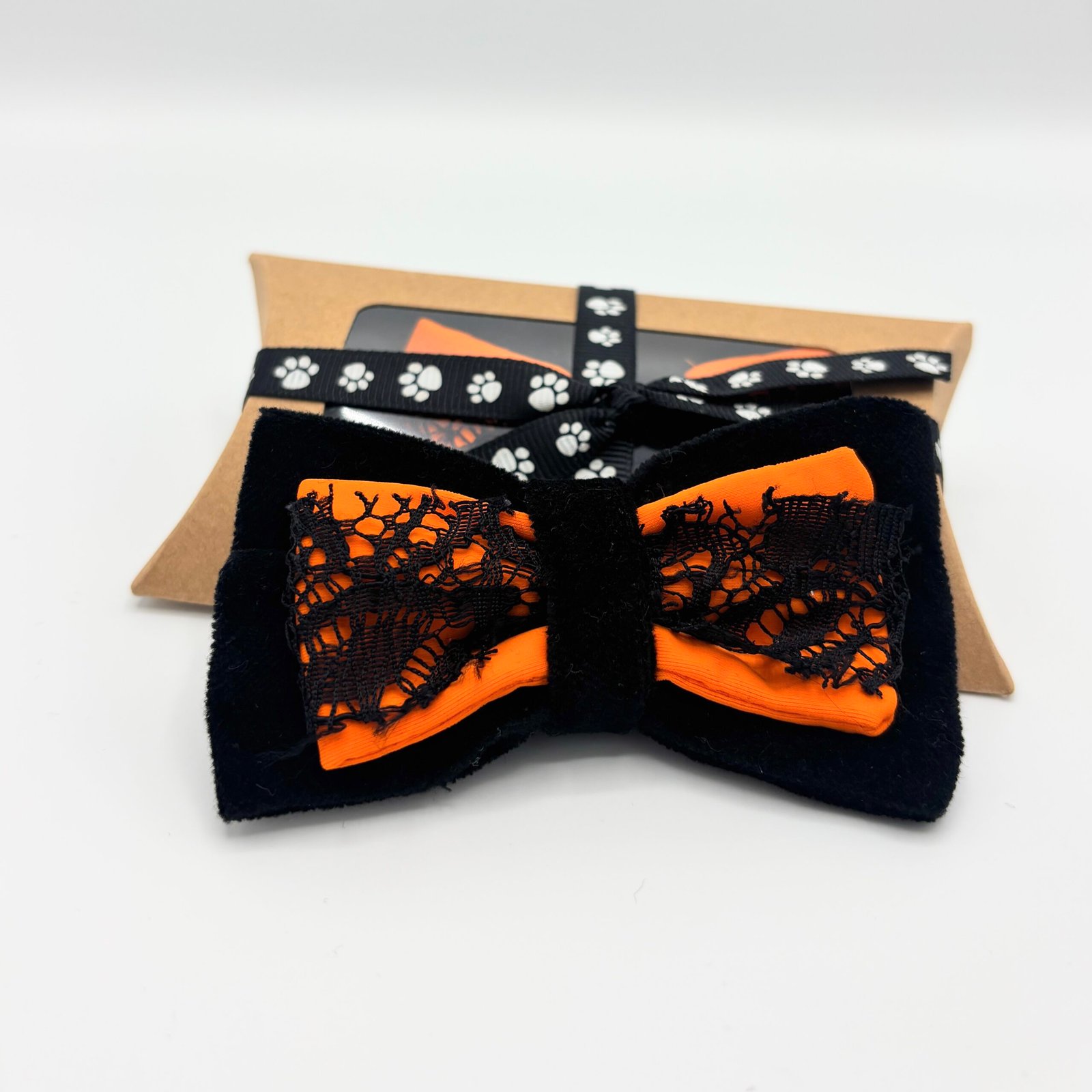 Front view of black and orange Halloween dog bow with lace trim and gift box